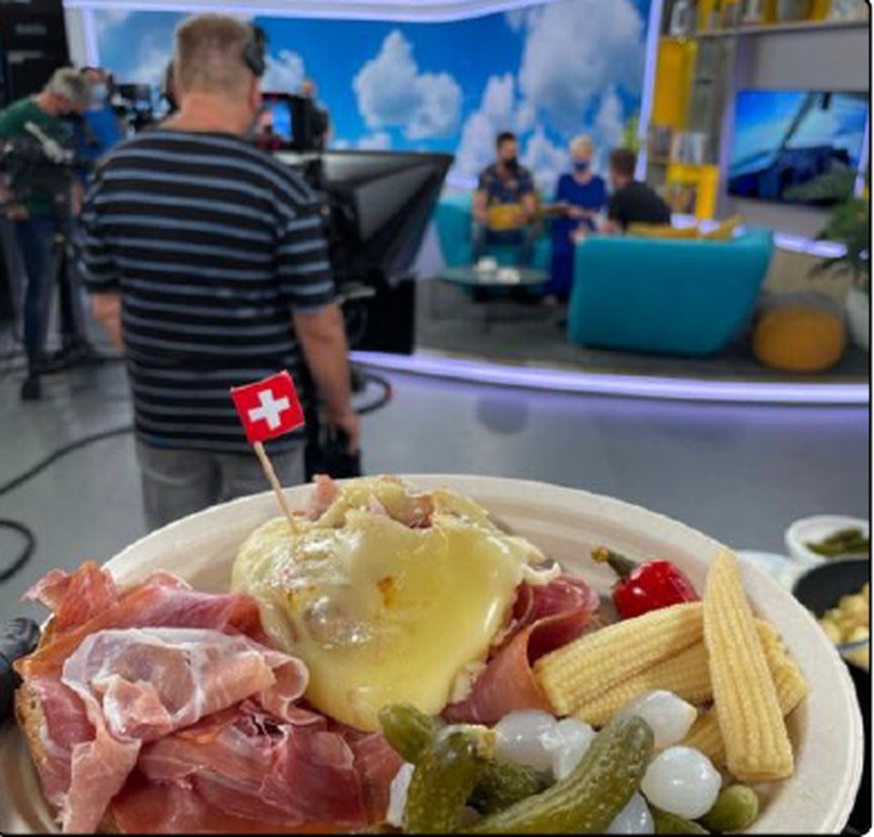 Talíř raclette se švýcarskou vlajkou v televizním studiu